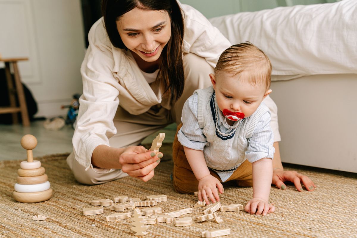 A young child absorbed in calm, focused sensory play on a soft floor