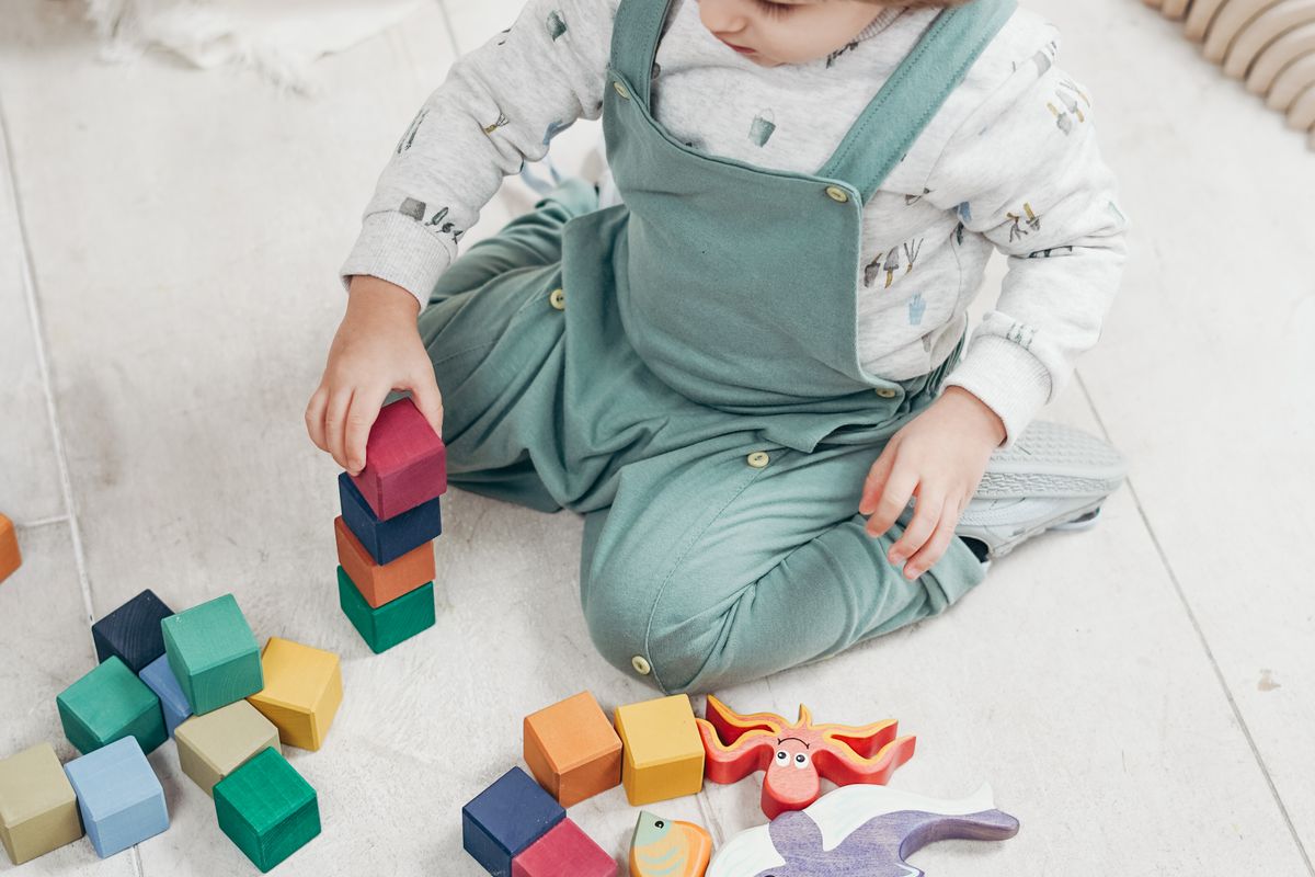 A child working out how to climb over a soft foam obstacle