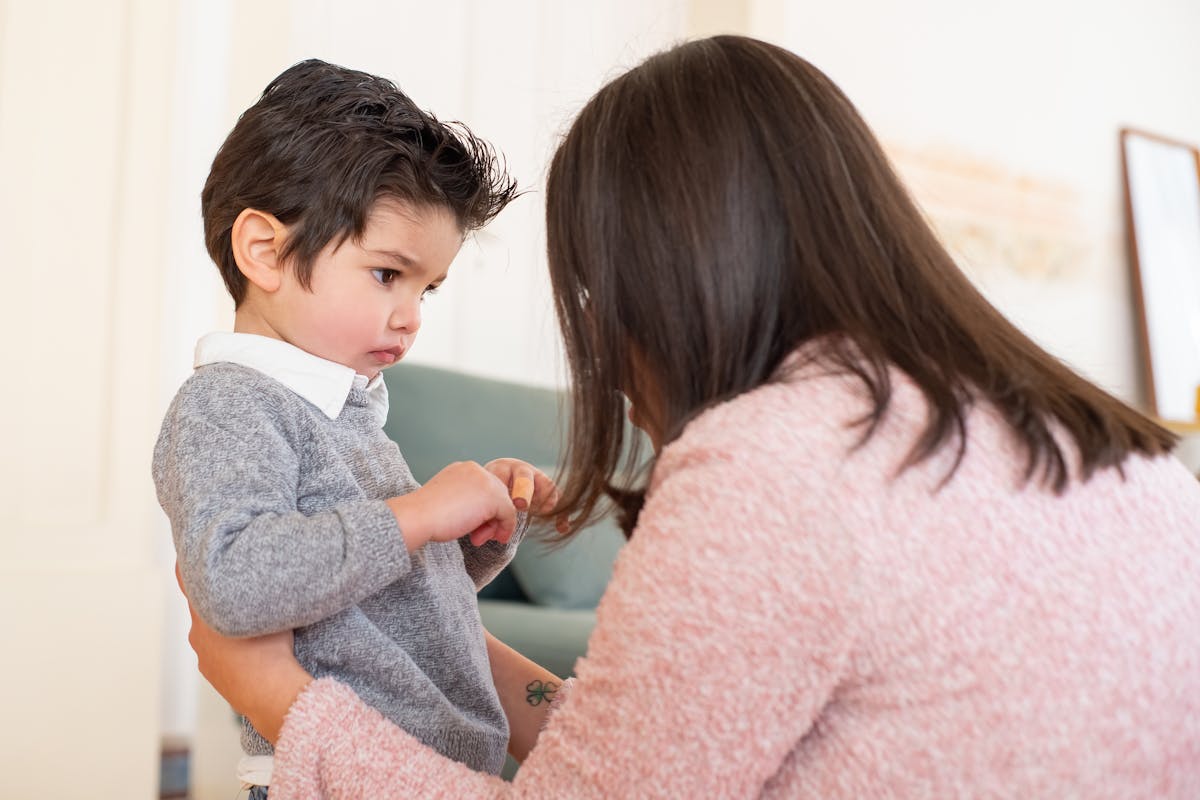 A parent crouching to a young child's eye level offering calm reassurance