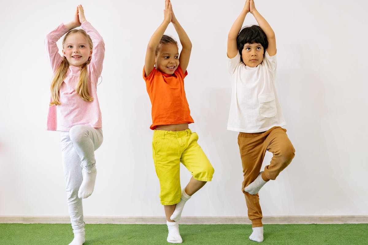 A child balancing happily on soft play equipment during active indoor play